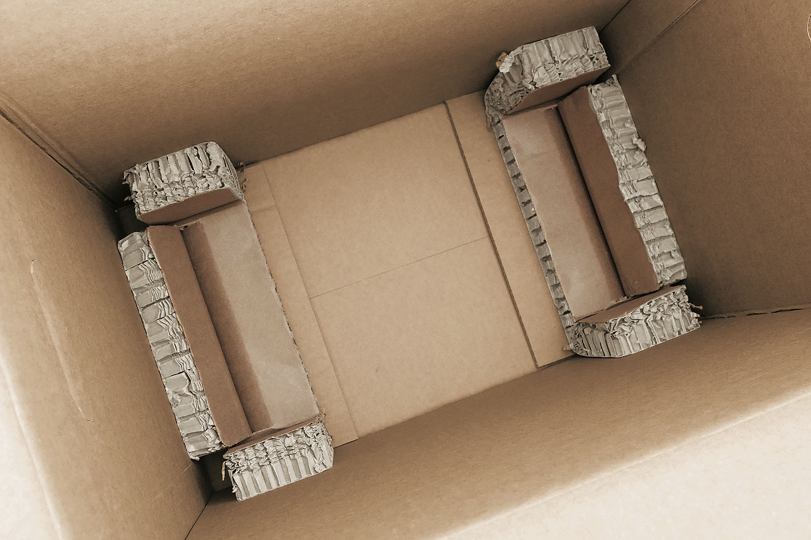 Rekkor®-Wabenpolster im Kartonboden bildet Schutzmulde für PC-Tower