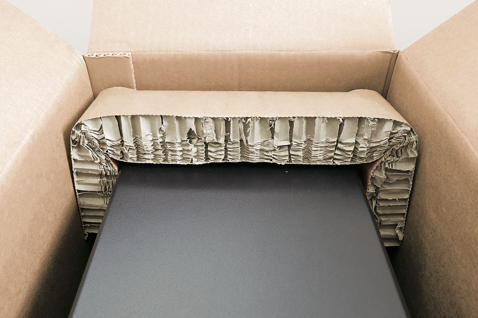 Rekkor®-Wabenpolster schützt Kanten und Ecken eines PCs im Versandkarton