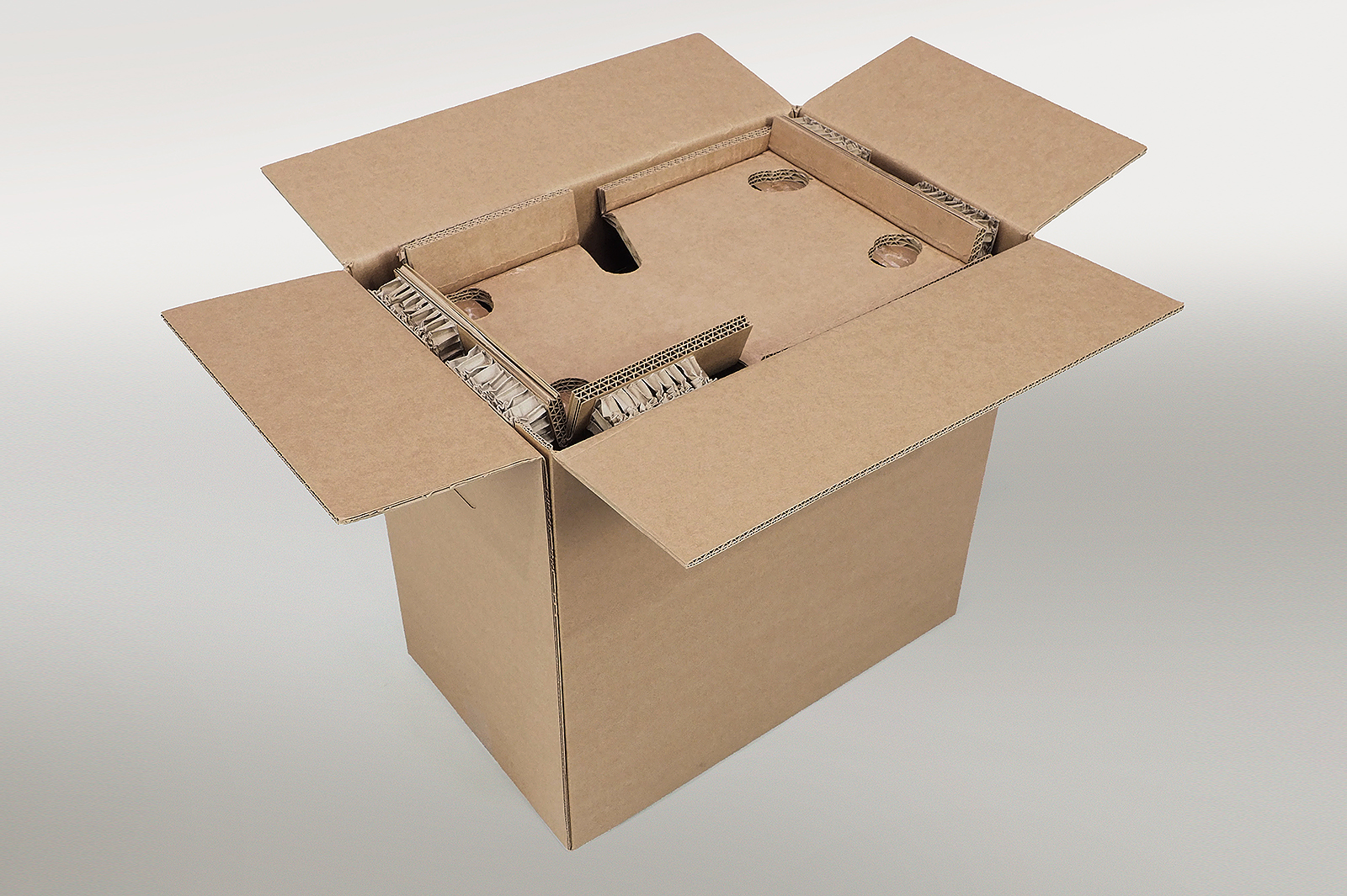 Einsetzen des Bodenpolsters mit Rekkor®-Wabenpolster in einen Versandkarton für eine Siebträgermaschine