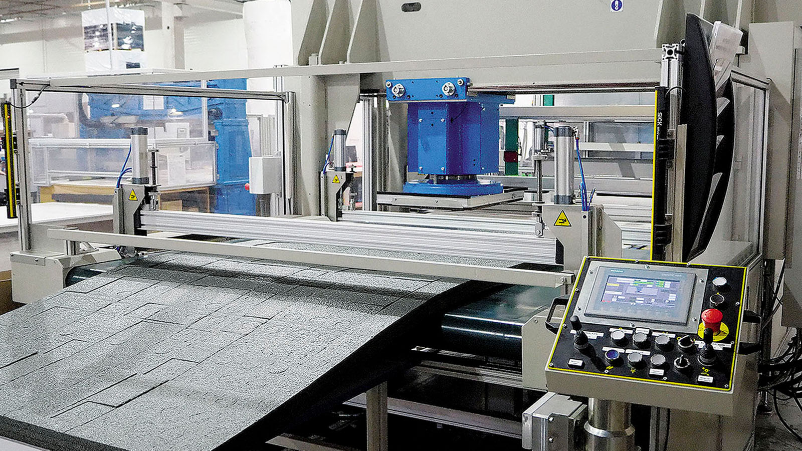 Maschine stanzt Formen aus einer Recycling-Schaumpolsterplatte zur Herstellung von nachhaltigen Verpackungen